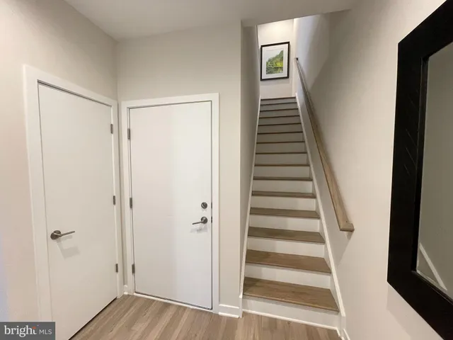 a view of a hallway with wooden floor and entryway