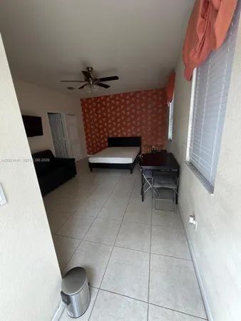 a bedroom with a chair and a potted plant on the dresser