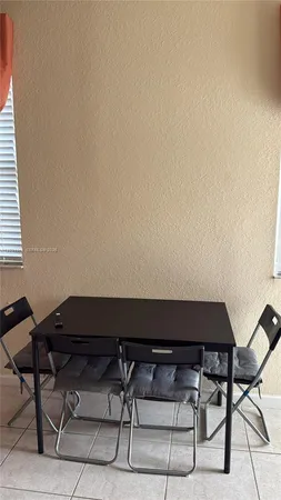 a view of patio with table and chairs under an umbrella