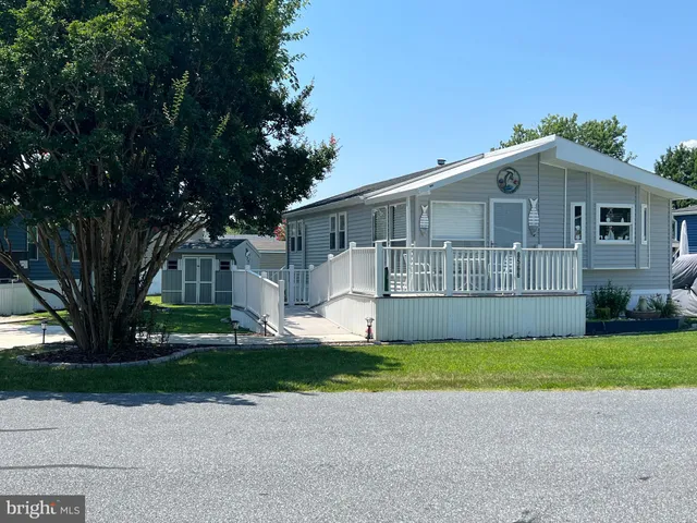 a view of a house with a yard and large trees