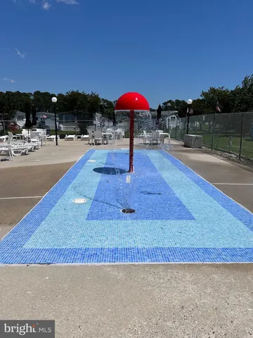 a view of a swimming pool with lawn chairs under an umbrella