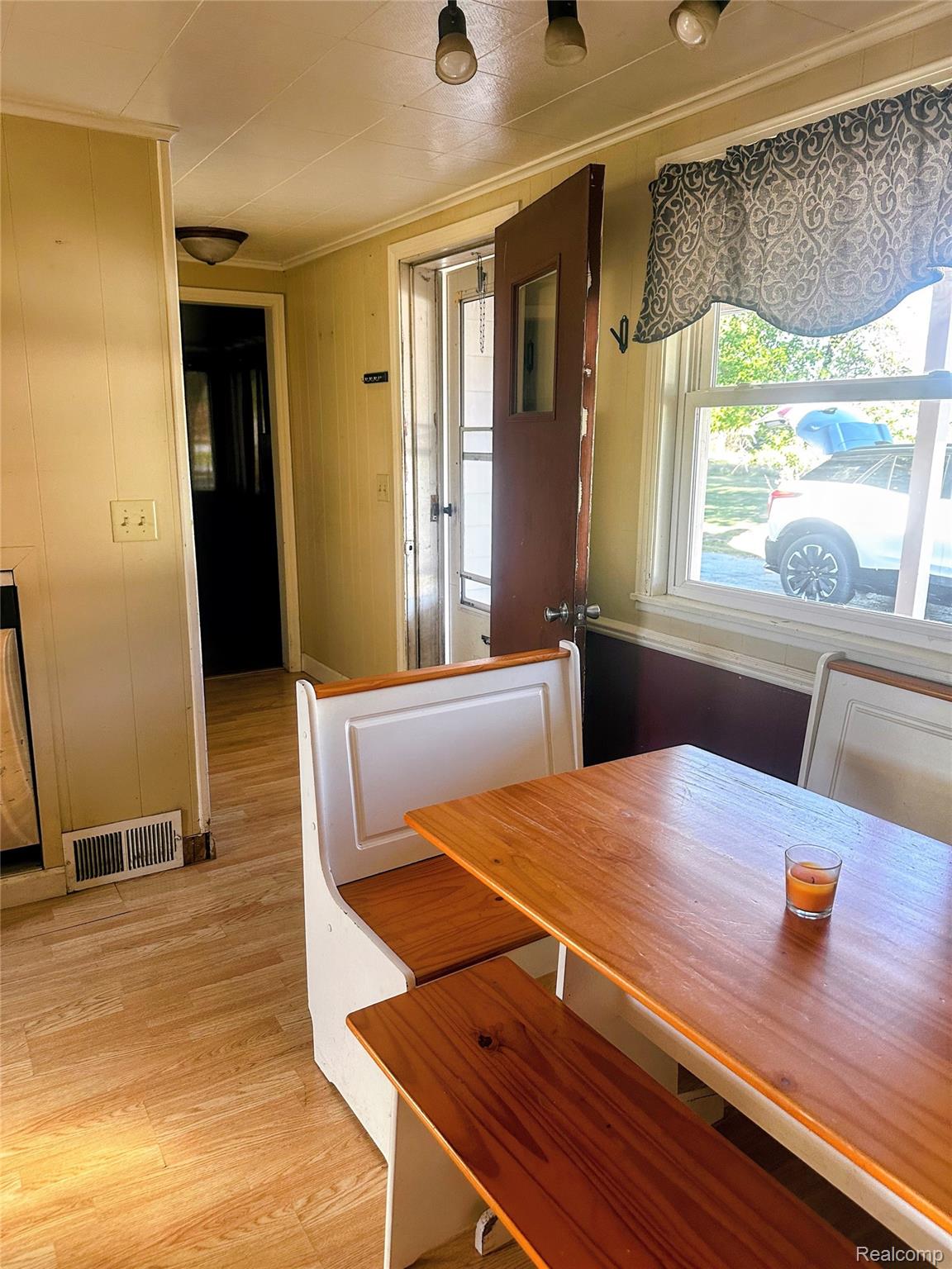 7305 West Gary Road Chesaning, MI 48616 - Photo 11 of 27 Wood-finish flooring, built-in bench seating, multiple light fixtures, and a glass-paneled exterior door