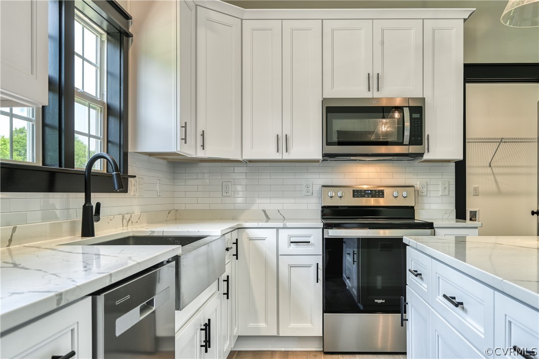 694 Gardners Road Mineral, VA 23117 - Photo 14 of 41 a kitchen with granite countertop a sink dishwasher stove and microwave with wooden cabinets