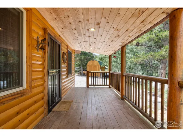 a view of a porch with wooden floor and iron fence