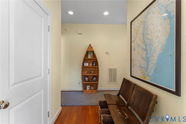 a view of a hallway with furniture and wooden floor