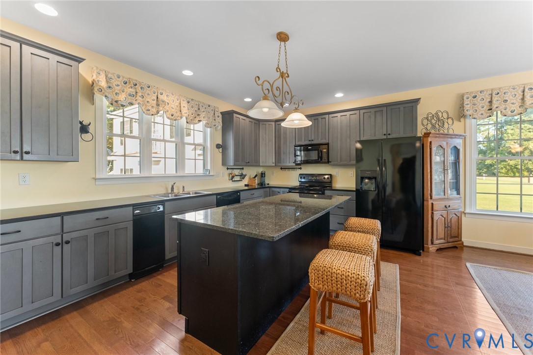 480 Rockingham Road Dunnsville, VA 22454 - Photo 20 of 41 a kitchen with stainless steel appliances granite countertop a refrigerator a sink dishwasher a stove and white countertops with wooden floor