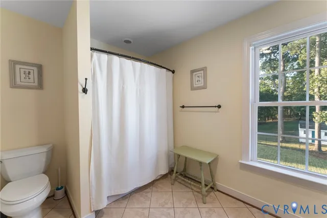 a bathroom with a toilet and a shower curtain