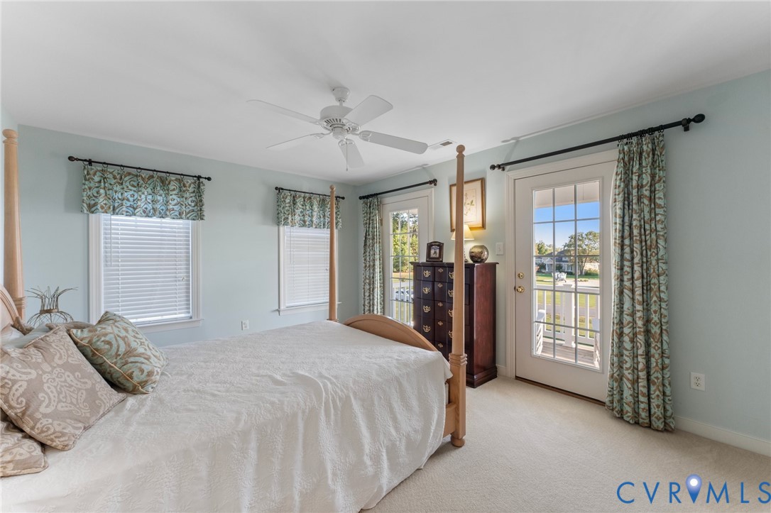 480 Rockingham Road Dunnsville, VA 22454 - Photo 35 of 41 a bedroom with a large bed and a chandelier