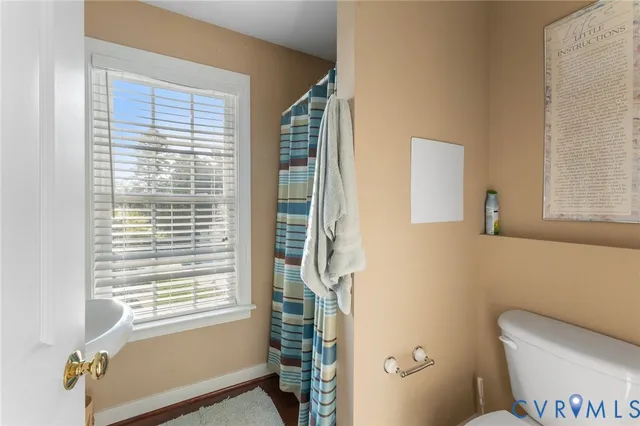 a bathroom with a toilet a sink and a window