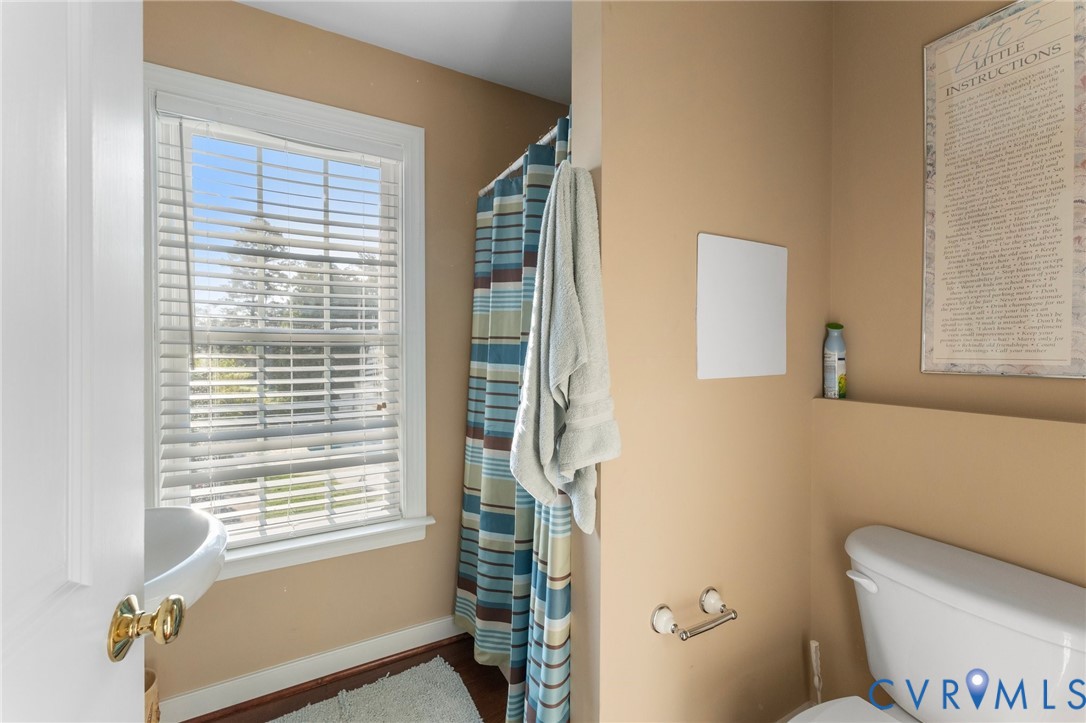 480 Rockingham Road Dunnsville, VA 22454 - Photo 41 of 41 a bathroom with a toilet a sink and a window