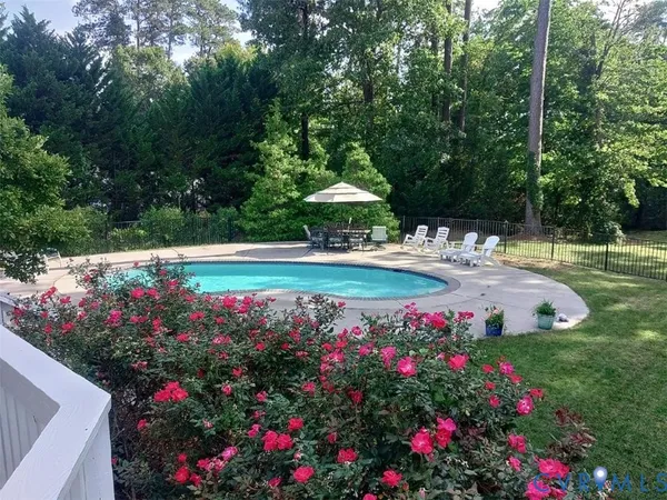 a view of a fountain in front of flowers and green space