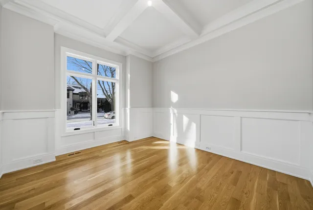 a view of an empty room with wooden floor and cabinet