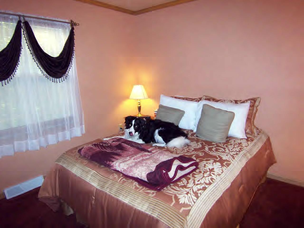 928 Heartwellville View Road Readsboro, VT 05350 - Photo 8 of 11 a bed sitting in a bedroom next to a window with a chandelier
