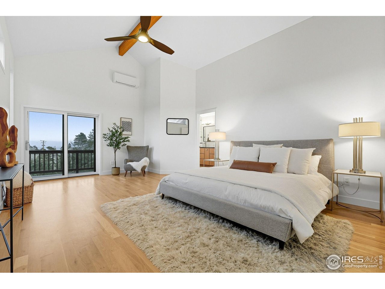 71 Ridge Drive Boulder, CO 80304 - Photo 18 of 42 a spacious bedroom with a bed a chandelier and a large window