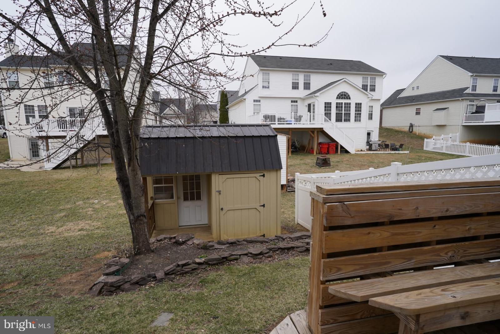 1217 Steed Street Ranson, WV 25438 - Photo 23 of 23 a view of a white house with a bed and wooden fence