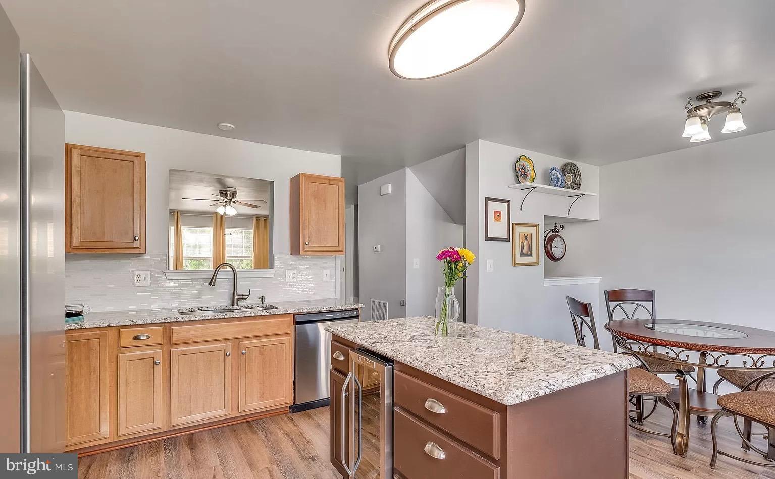 1217 Steed Street Ranson, WV 25438 - Photo 6 of 23 a kitchen with a granite countertop sink and a stove with wooden floor