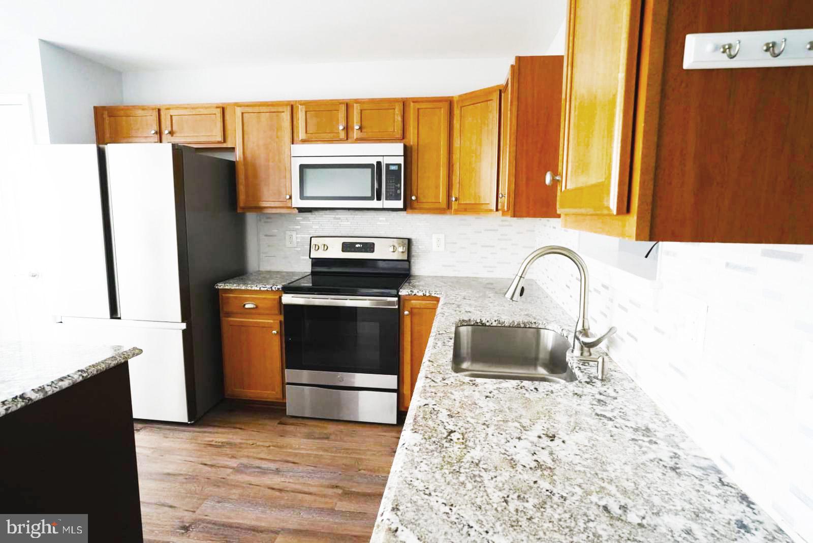 1217 Steed Street Ranson, WV 25438 - Photo 8 of 23 a kitchen with stainless steel appliances a stove microwave and a refrigerator