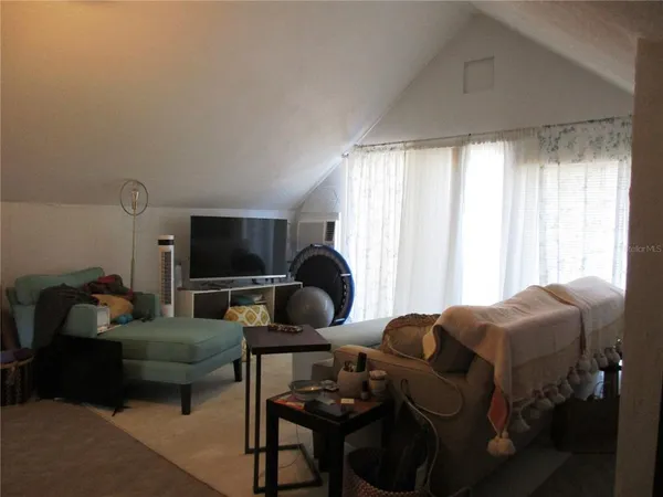 a living room with furniture a flat screen tv and a large window