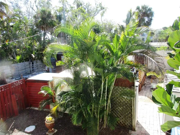a view of a backyard with chairs potted plants