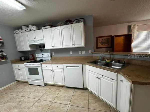 a kitchen with white cabinets and white appliances