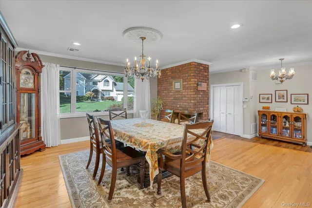 a view of a dining room with furniture a chandelier and wooden floor