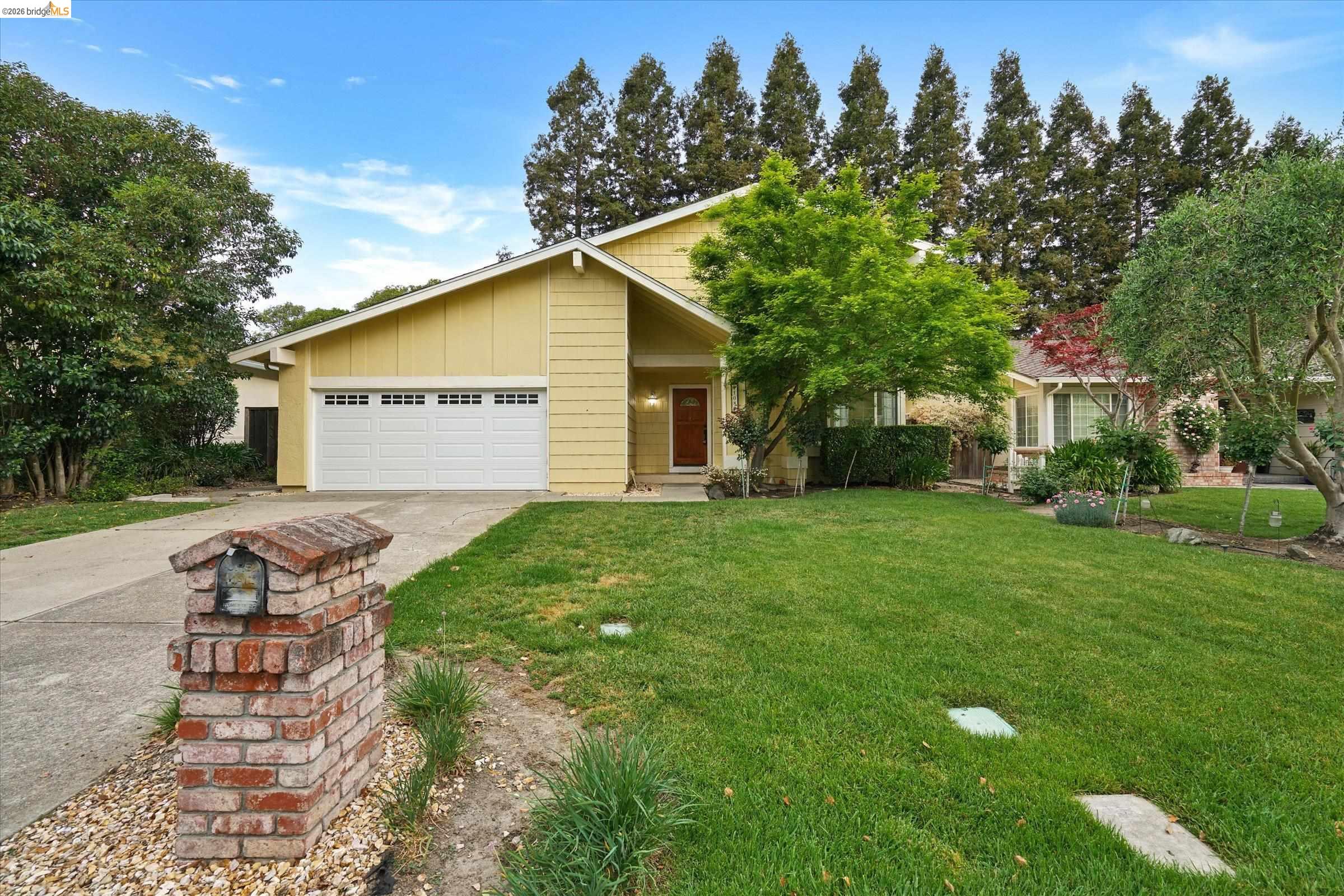 View of front of property with a garage, driveway, a front lawn, and board and batten siding
