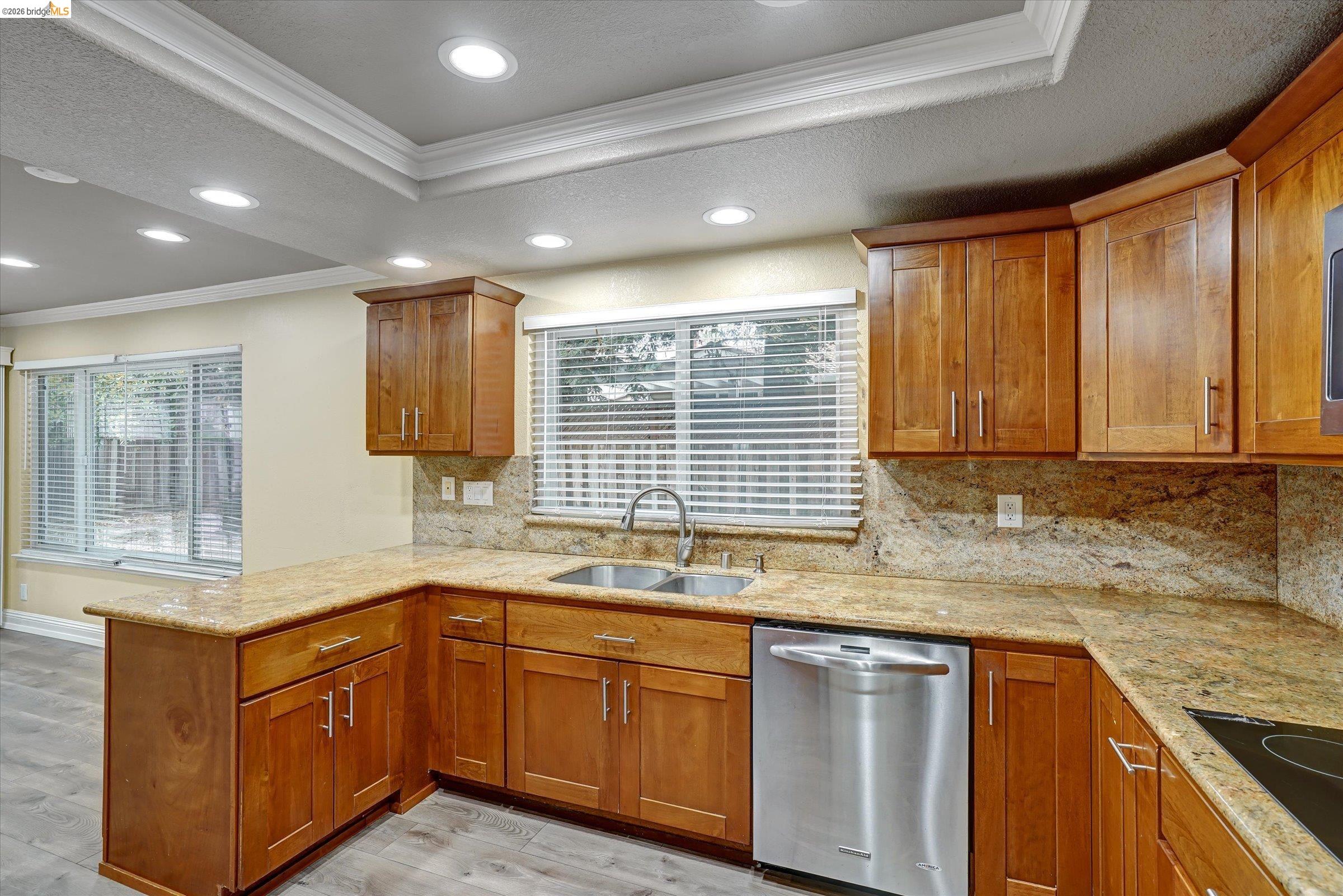 108 Castleton Court San Ramon, CA 94583 - Photo 11 of 41 Kitchen with ornamental molding, dishwasher, a peninsula, wood finish cabinetry, and light wood-style flooring