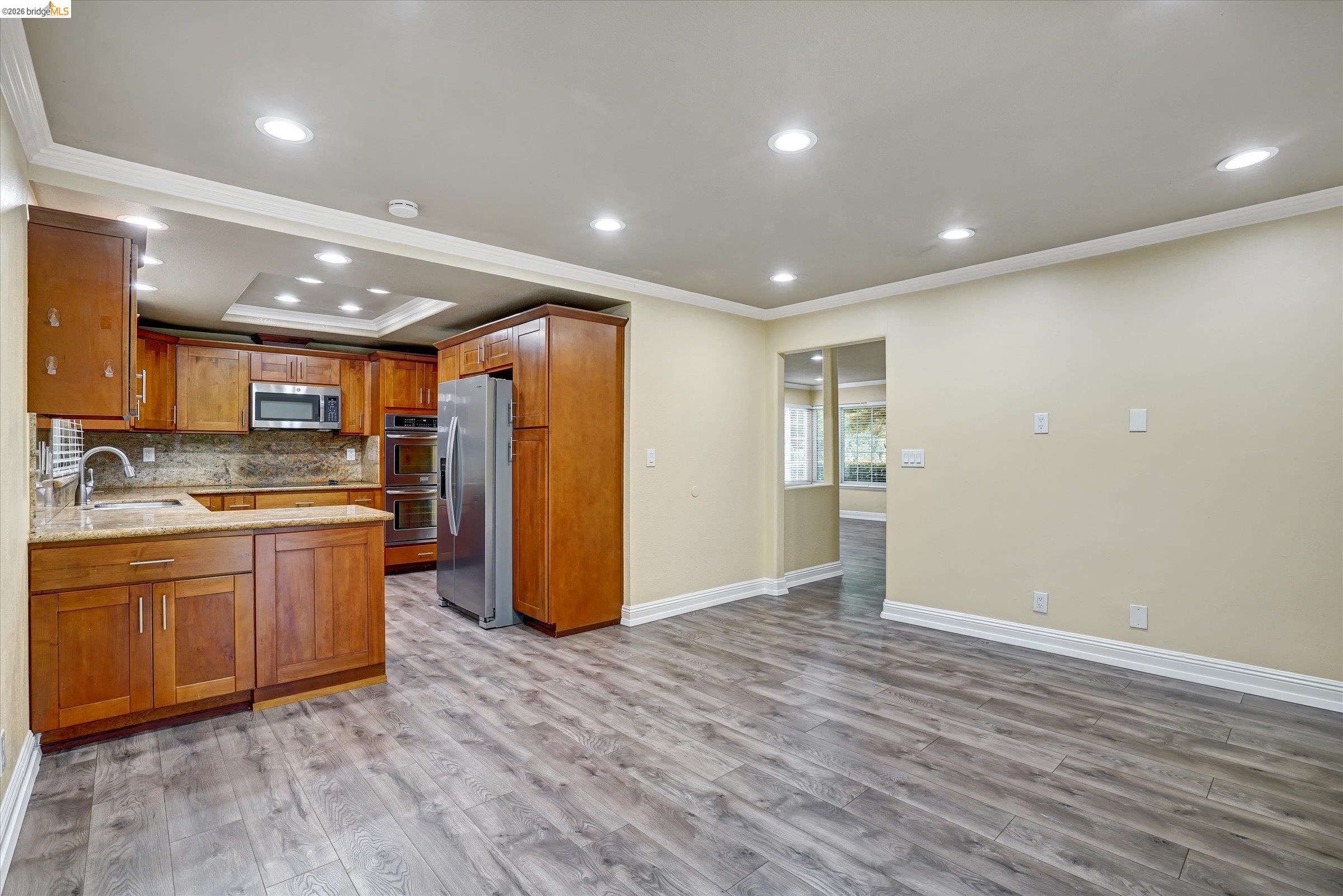 108 Castleton Court San Ramon, CA 94583 - Photo 16 of 41 Kitchen featuring light stone countertops, crown molding, wood finish cabinets, stainless steel appliances, and tasteful backsplash