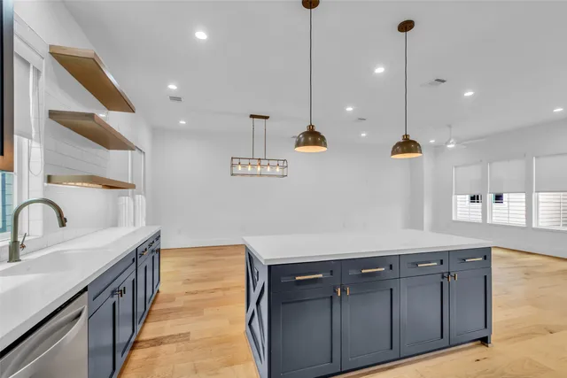 a kitchen with a sink a counter space appliances and cabinets