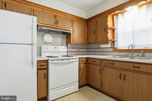 a kitchen with stainless steel appliances granite countertop a sink cabinets and a refrigerator