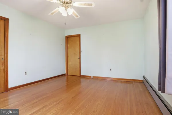 a view of an empty room with wooden floor
