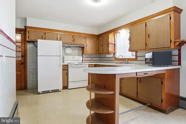 a kitchen with kitchen island granite countertop cabinets and white appliances