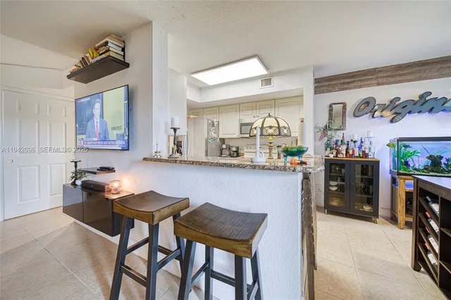a kitchen with stainless steel appliances kitchen island granite countertop a table and chairs in it
