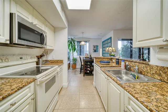 a kitchen with stainless steel appliances granite countertop a sink and a microwave