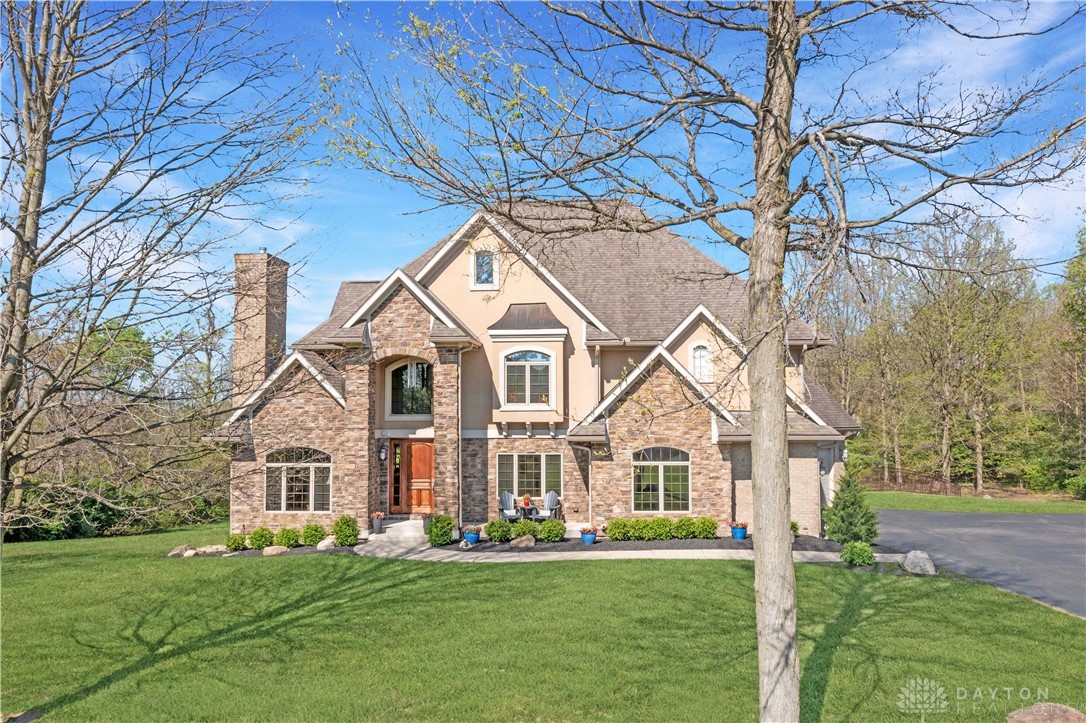 4096 Middle Urbana Road Urbana, OH 43078 - Photo 62 of 96 This grand residence showcases a captivating blend of stone and stucco, featuring a prominent chimney and inviting front patio.