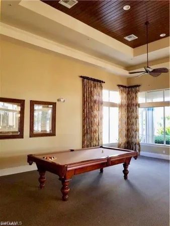 a living room with a pool table and windows