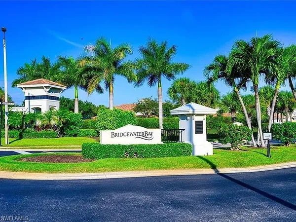 a view of a house with a yard and palm trees