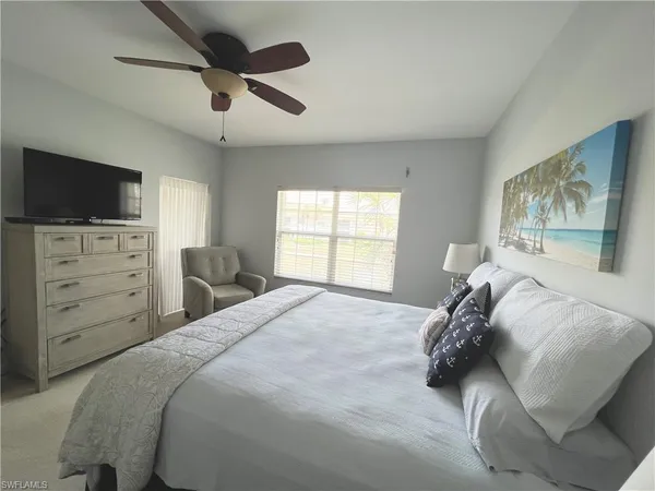 a bedroom with a bed a window and a television