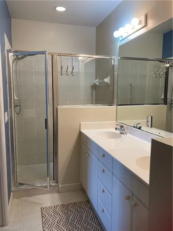 a bathroom with a shower sink and mirror