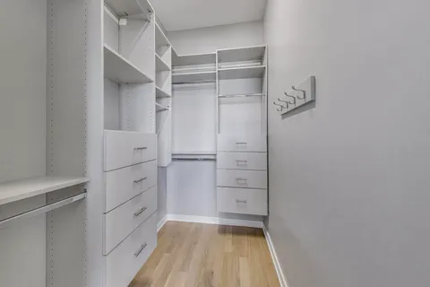 a view of walk in closet with empty racks