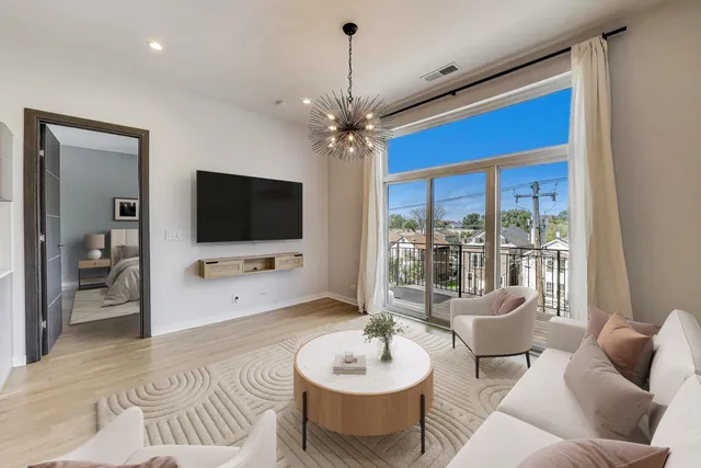 a living room with furniture a flat screen tv and a large window