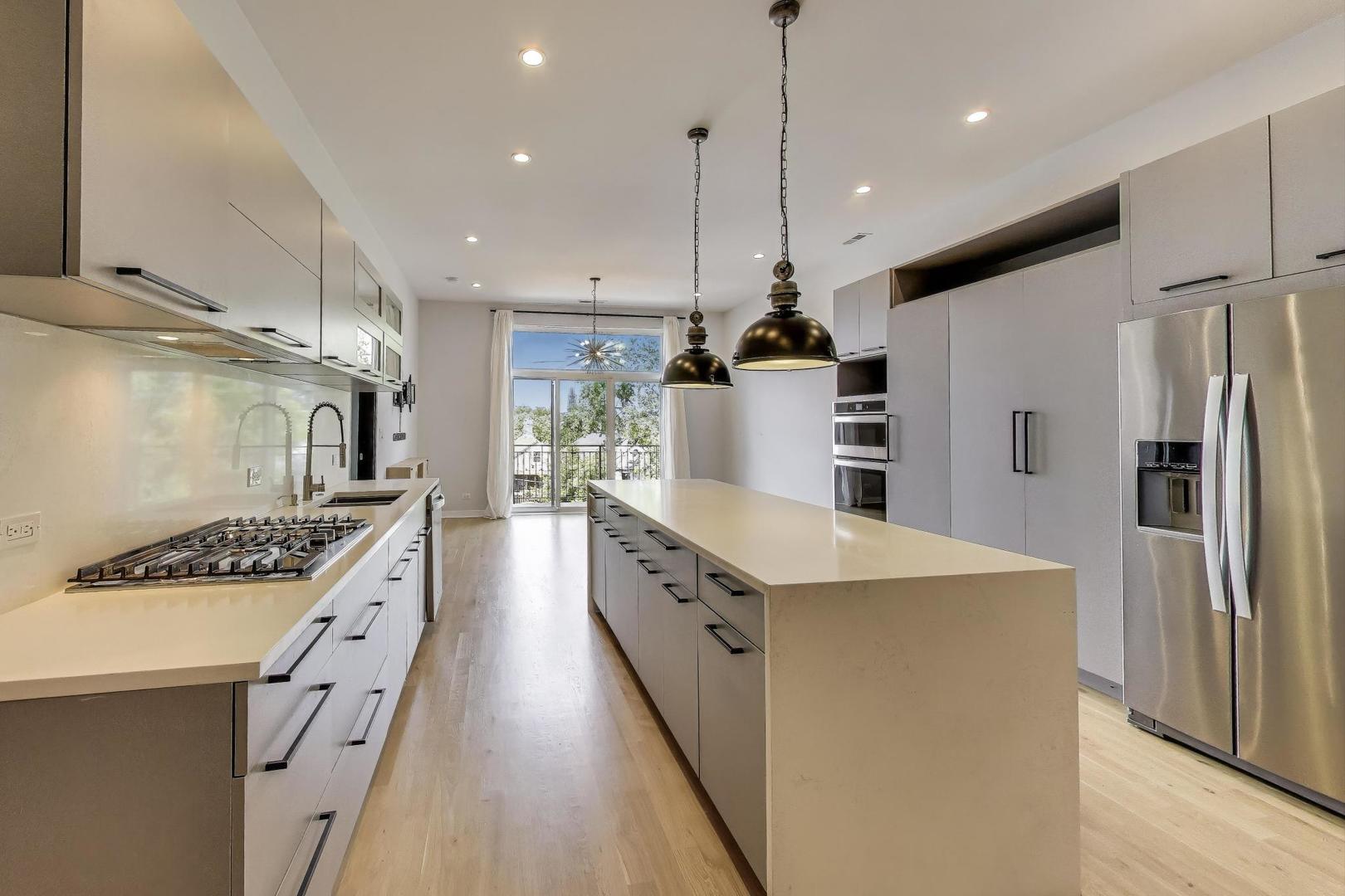 1708 West Cermak Road, Unit 3W Chicago, IL 60608 - Photo 8 of 26 a kitchen with stainless steel appliances granite countertop a refrigerator a stove and a wooden floors