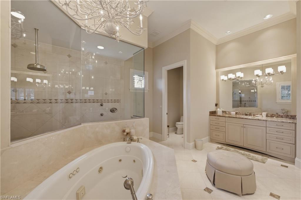361 Pirates Bight Naples, FL 34103 - Photo 23 of 45 a large white bathroom with a large tub a sink a toilet a mirror and shower