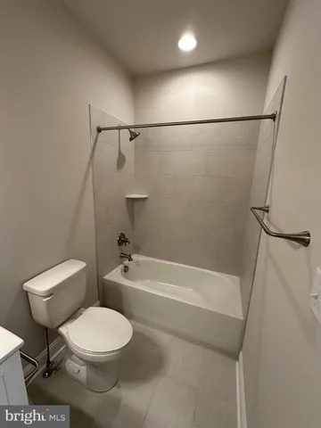 a white toilet and tub sitting next to a bathroom sink