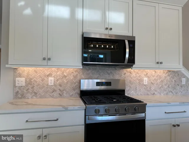 a stove top oven sitting inside of a kitchen