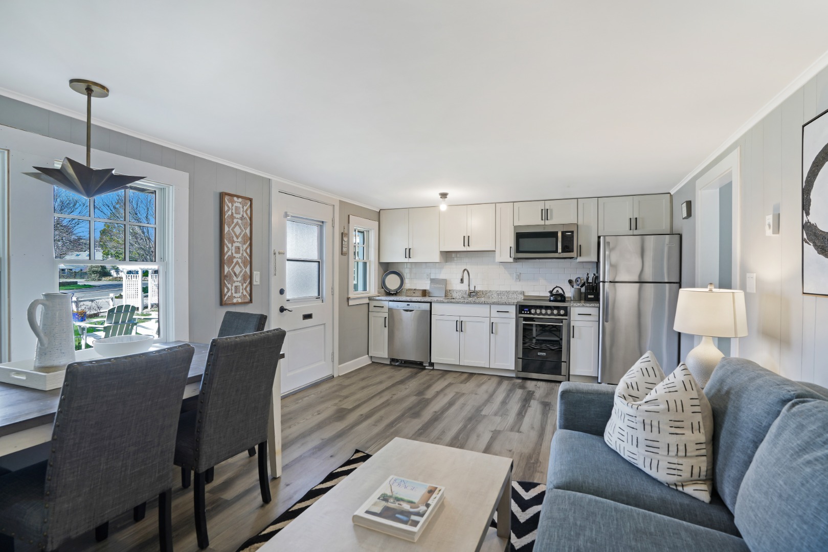 20 Peases Point Way North, Unit 4 Edgartown, MA 02539 - Photo 4 of 11 a living room with furniture and a dining table with kitchen view