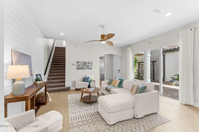 a view of a dining room and livingroom with furniture wooden floor a chandelier