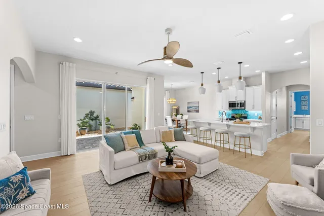 a large kitchen with kitchen island a refrigerator a stove a sink dishwasher a oven and a dining table with wooden floor