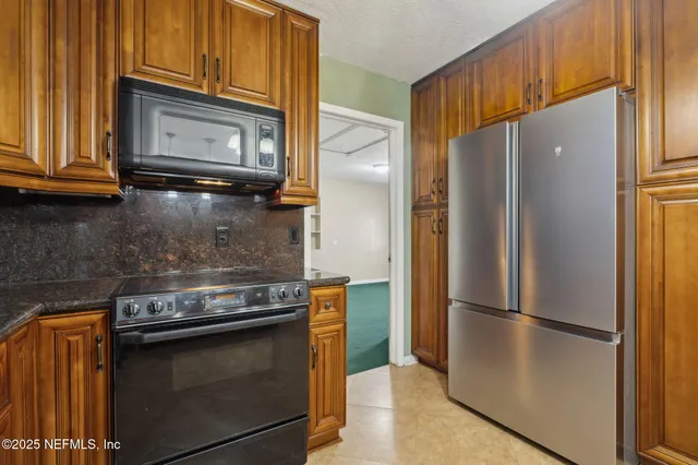 a metallic refrigerator freezer sitting in a kitchen