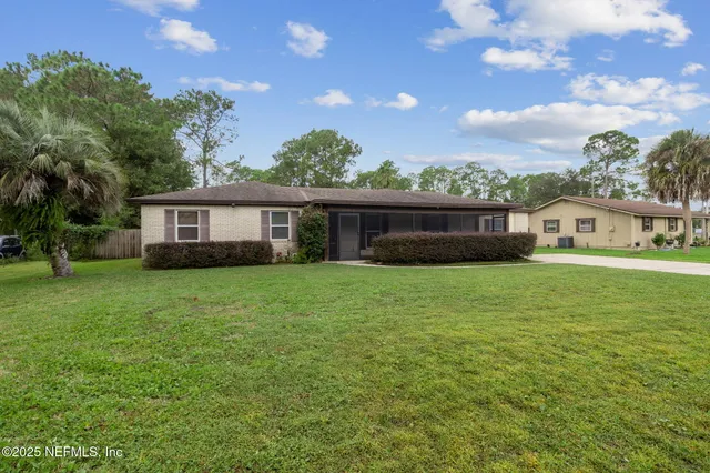 a front view of a house with a garden and lake view